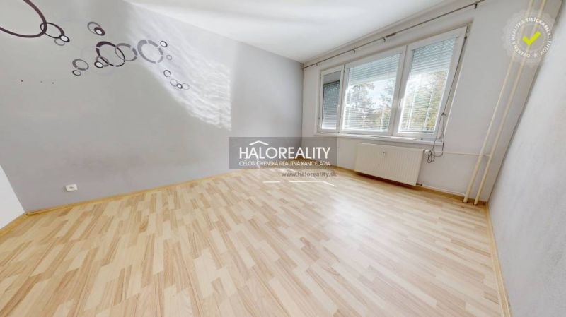 A room with a wooden decor floor, gray walls, and large windows in a studio apartment.