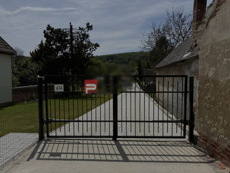 Gate with a paved driveway in Borinka, on Borinka Street, Residential plots.