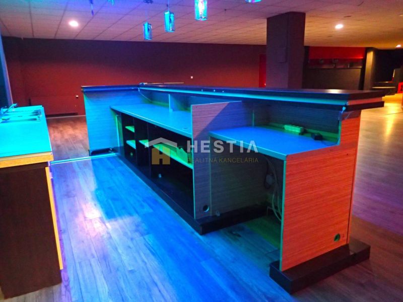 Night bar with a lit counter, wooden floor, and space for commercial premises.