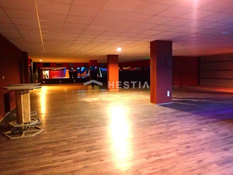 Spacious commercial spaces with wooden flooring and columns, suitable for various purposes.