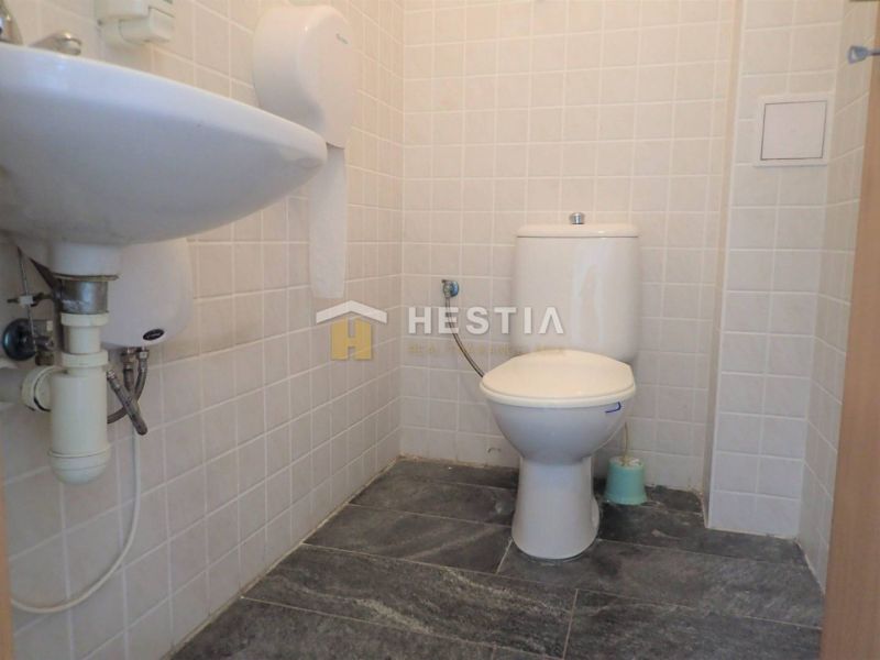 A restroom in premises designated for commercial land with ceramic tiles and a sink.