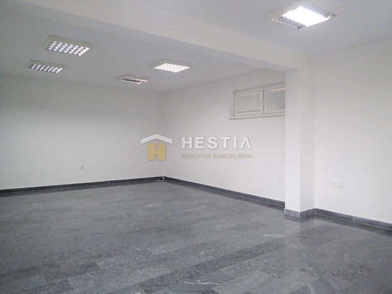 Spacious commercial space with tiles and ceiling lights, suitable for commercial land.