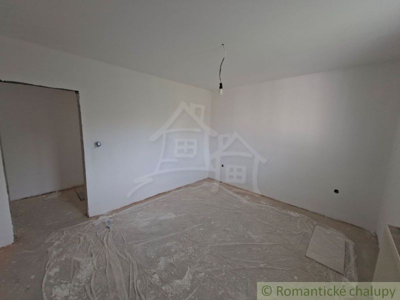 A room in a family house with white walls and a wooden decor floor.