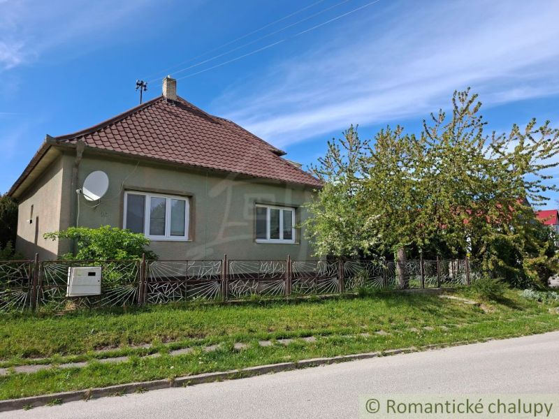 A family house in Orešany with a red roof and a well-maintained garden.