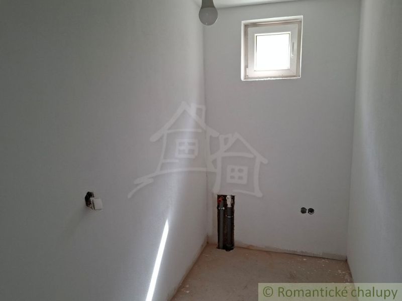 A small room in a family house with a window and preparation for installations.