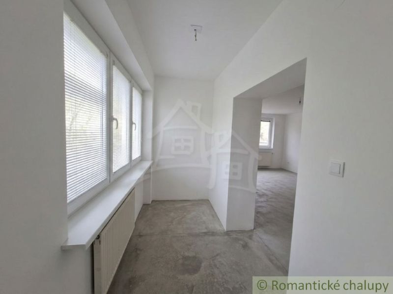 The interior of a family house with white walls and windows with blinds.