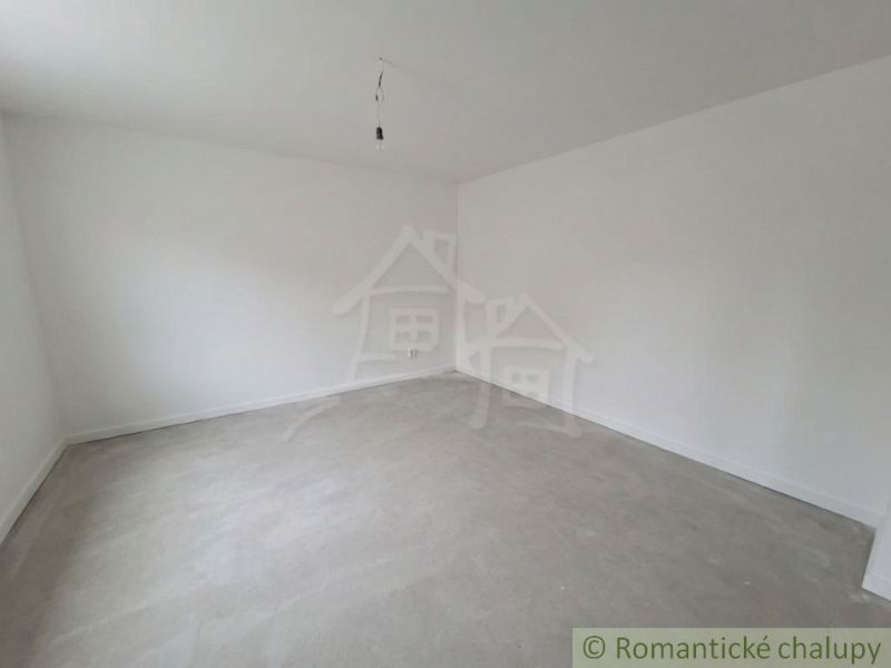 Empty room with white walls and exposed concrete surface in a family house.
