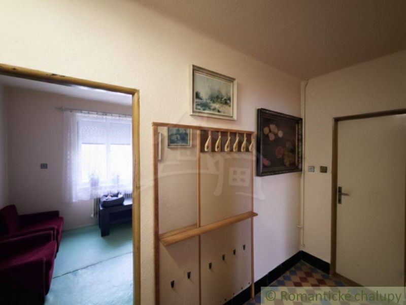 A hallway in a family house with a wardrobe and a view of the room.