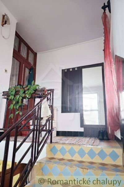 A staircase in a family house with colorful tiles and a curtain.