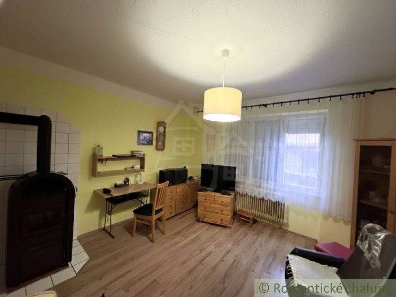Living room with tiles, wooden furniture, and a floor with a wood design.