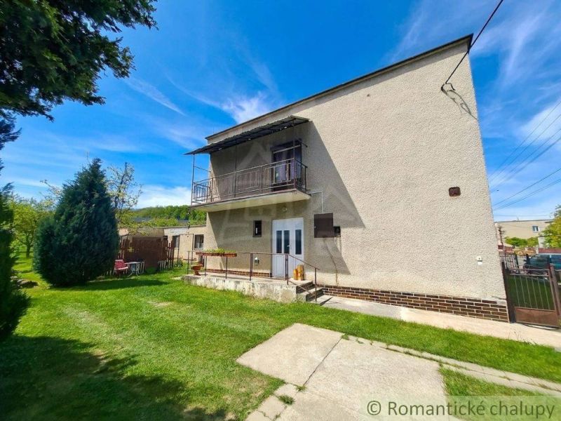 A family house in Mýtna with a garden and a balcony under the blue sky.