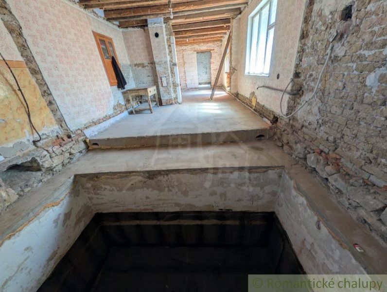 The interior of a family house under renovation with exposed walls and a staircase.