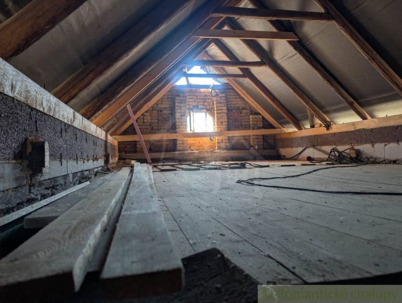 An attic with exposed beams and a wooden decor floor in a family house.