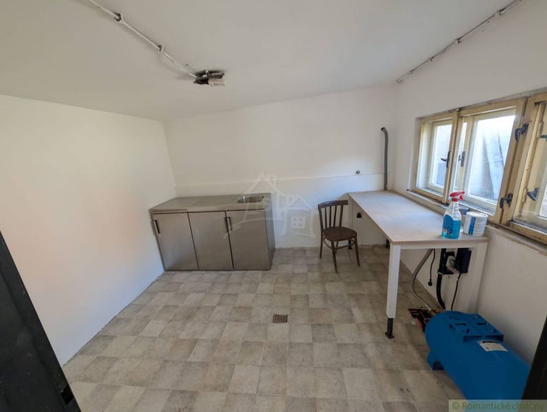 Interior of a family house with a wooden table, chair, and cabinet with a sink.