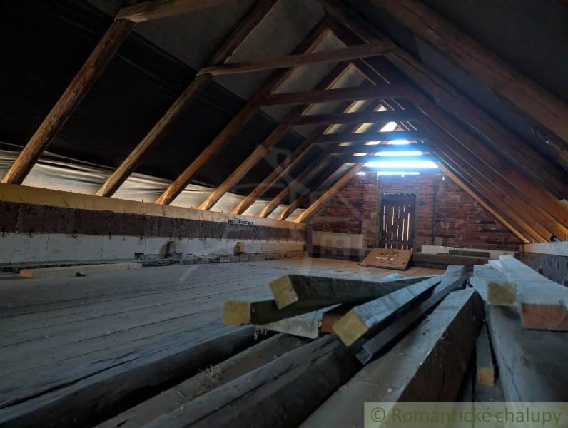 The attic of a family house with wooden beams and stored wood.