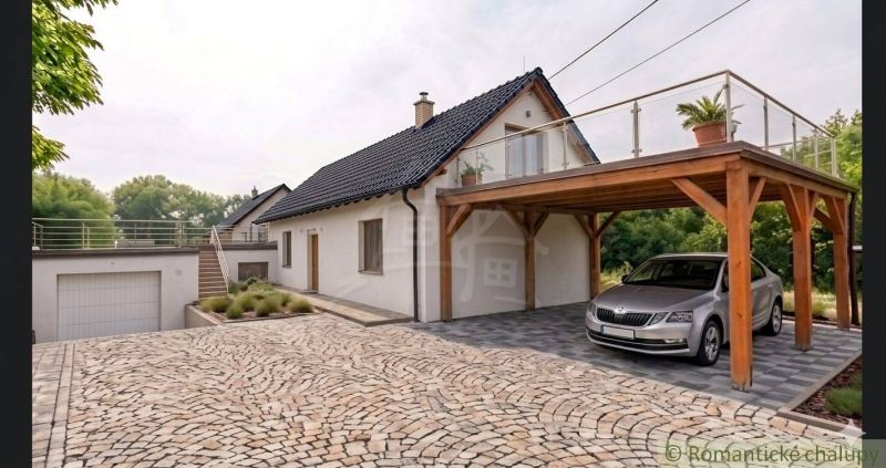 A family house in Sobotište with a sloped roof, terrace, and wooden carport.