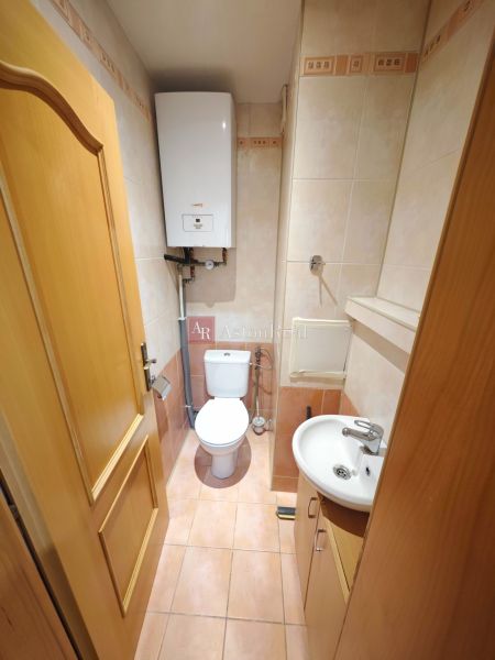 Bathroom in a 3-room apartment with a shower, sink, and boiler, tiles in soft shades.