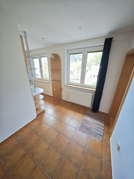 A room in a 3-room apartment with tiles, windows, and shelves.