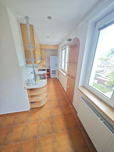 A cozy kitchen with a view and tiles in a 3-room apartment.