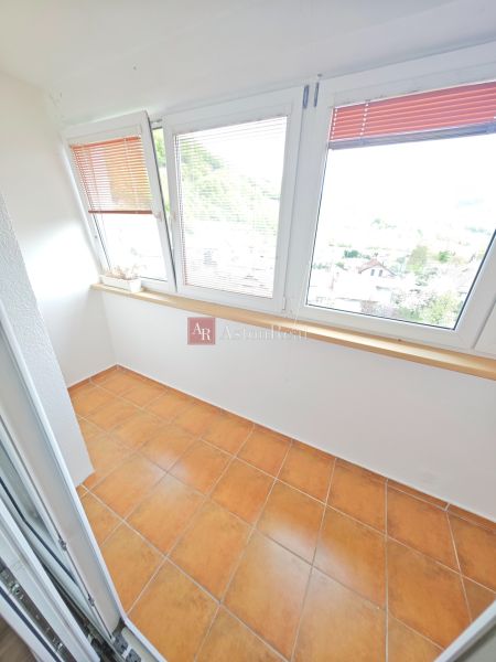 A bright loggia with glass and terracotta tiles in a 3-room apartment.