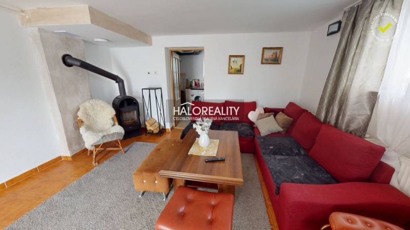 Living room in a family house with a fireplace, a comfortable sofa, and a wooden table.