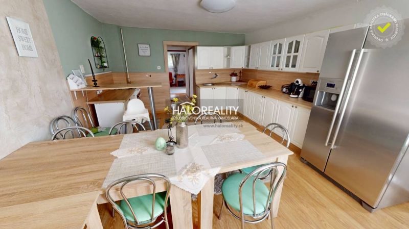 A kitchen in a family house with white cabinets and a wooden decor floor.