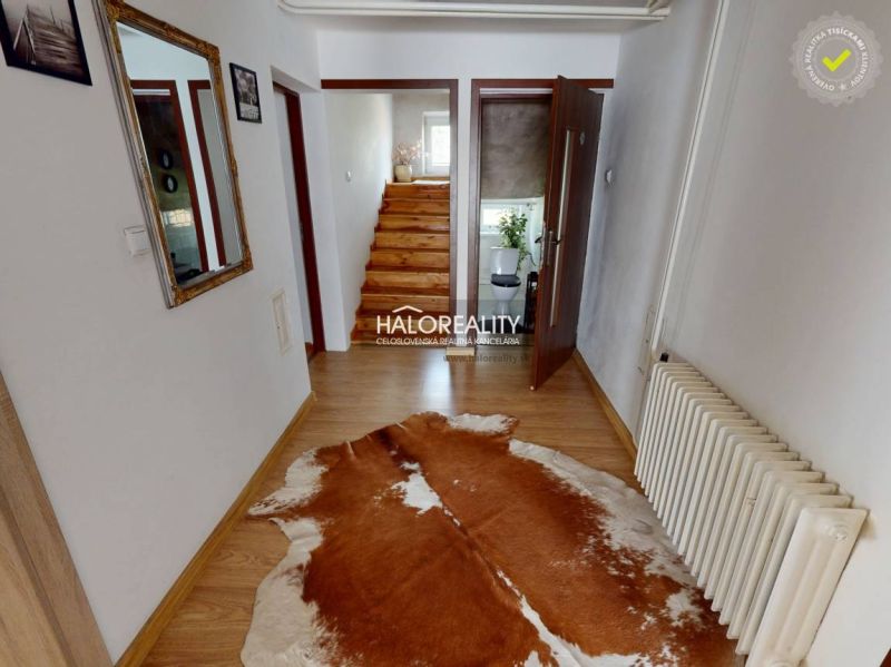 Interior of a family house with a wooden decor floor and a staircase with a railing.