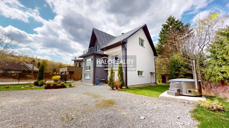 A family house in Vitanová surrounded by a garden and a paved access road.