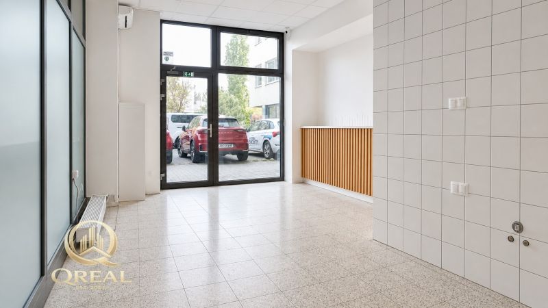 A bright room with large windows and tiled flooring, ideal for commercial spaces.