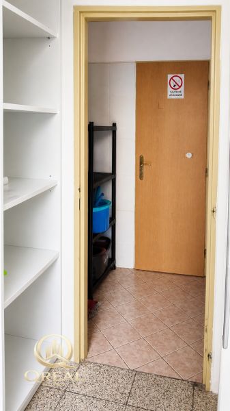 In the commercial premises, there are white shelves, doors, and a cleaning rack.