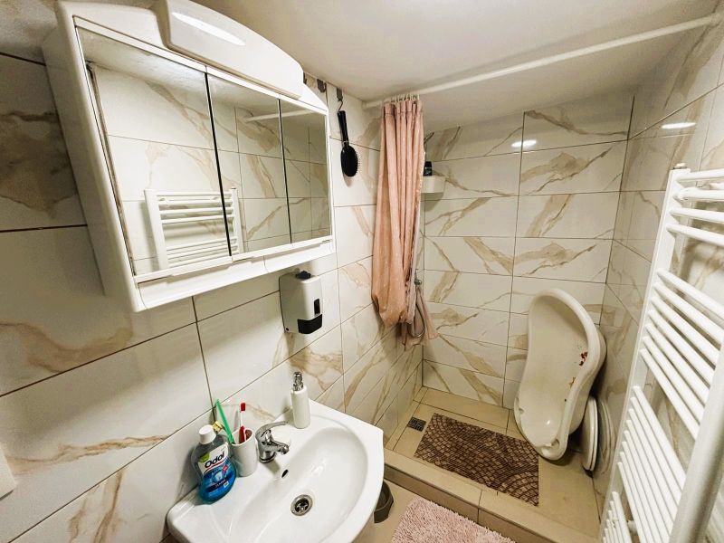 A bathroom in a cabin with a white sink, a mirrored cabinet, and a shower corner.