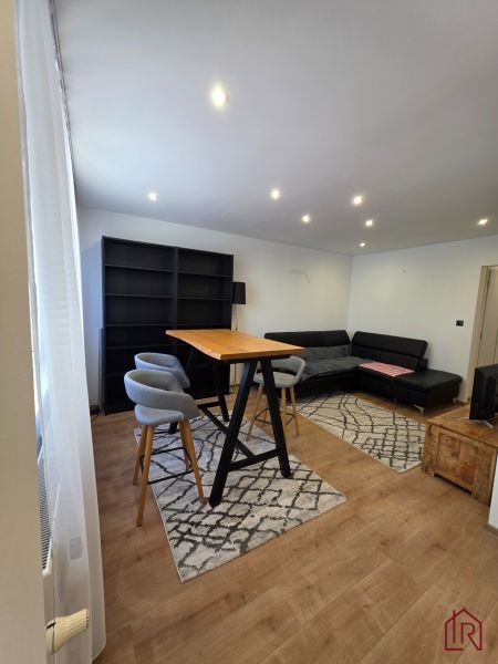 Living space in a 3-room apartment with wood-patterned flooring and furniture.