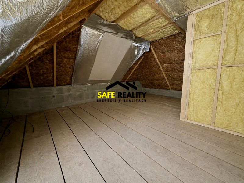 The attic of a family house with a wooden decor floor and insulation.