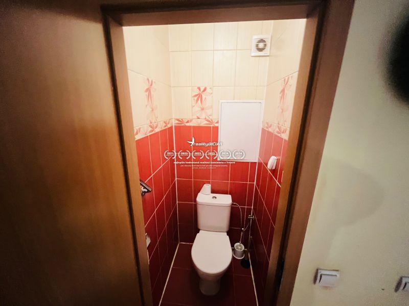 A bathroom with red tiles in a 3-room apartment.