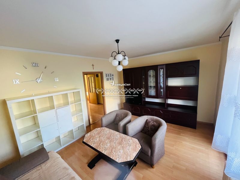 Living room in a 3-room apartment with wooden decor, white and dark cabinet.