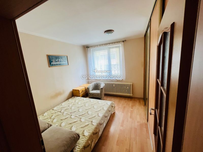 Bedroom with a double bed and wooden decor flooring in a 3-room apartment.
