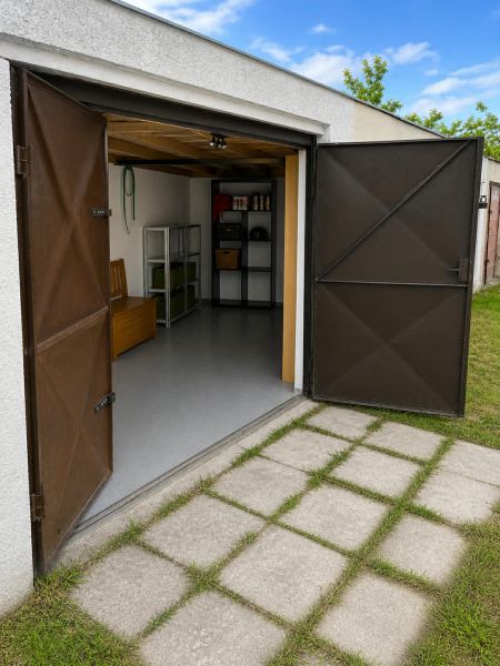 Open garage on Gúgska Street in Nové Zámky with shelves and a flat lawn.