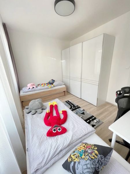 Children's room in a 3-room apartment with toys and a floor with a wooden decor.
