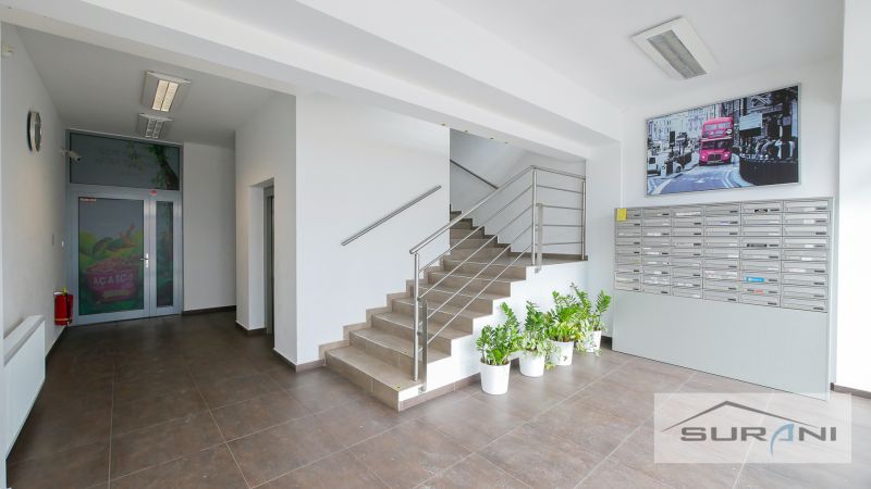 A staircase with stainless steel railing and mailboxes in the office.