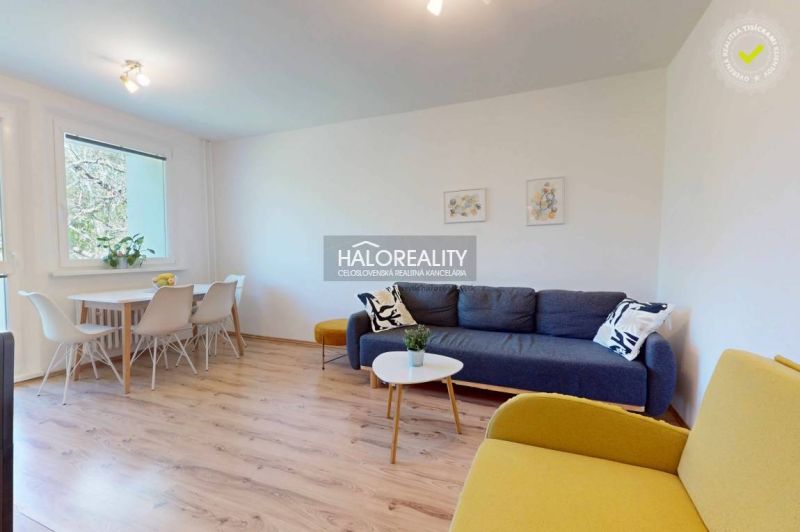 Living room in a three-room apartment with a wooden decor floor and light furniture.