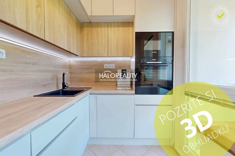 A kitchen in a 3-room apartment with light cabinets and a wood-patterned floor.