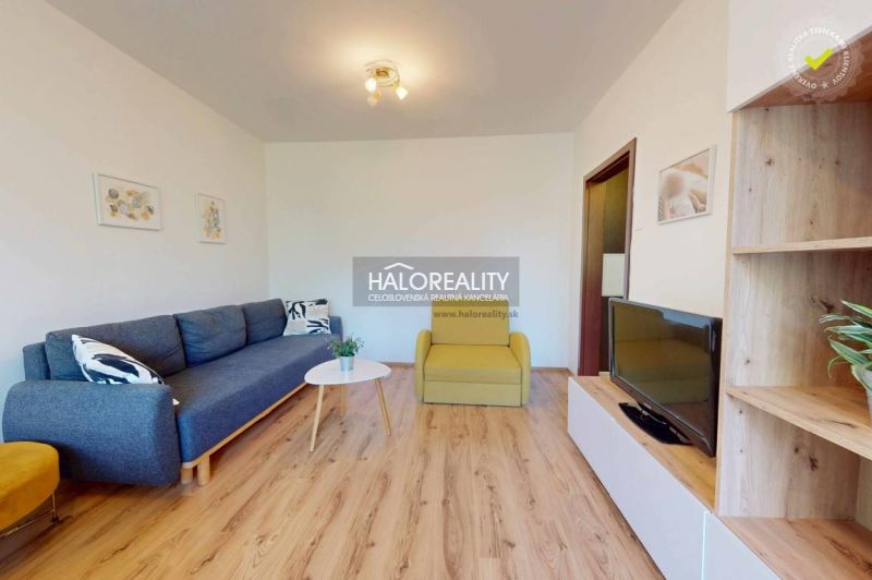 Living room with a corner sofa in a 3-room apartment, wooden decor flooring, modern interior.
