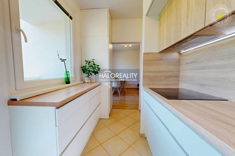 A kitchen in a 3-room apartment with tiles and a wooden decor floor.