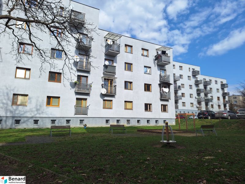 An apartment building on Majakovského Street in Prešov surrounded by greenery and a parking lot.