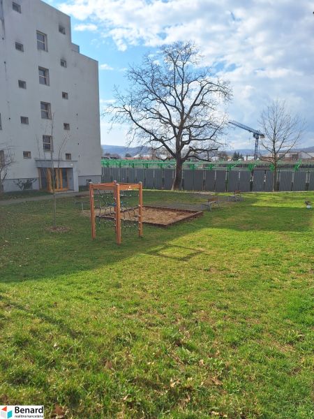 A courtyard by a 2-room apartment on Majakovského in Prešov with a lawn and trees.