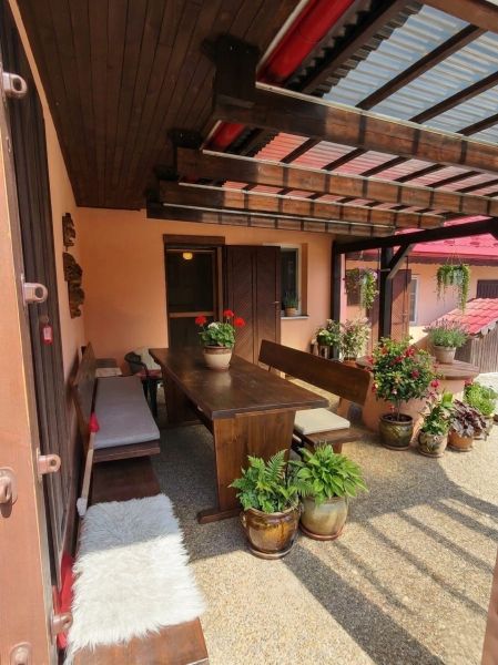 The terrace of a family house in Lakšárska Nová Ves in Mikulášov with wooden seating and flowers.