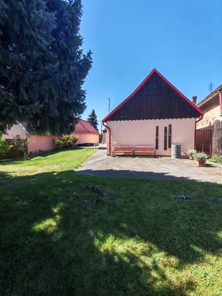 A family house on Mikulášov Street in Lakšárska Nová Ves with a landscaped garden and benches.