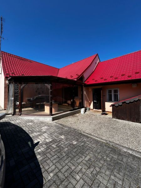 A family house in Lakšárska Nová Ves in Mikulášov with a red roof and a paved courtyard.