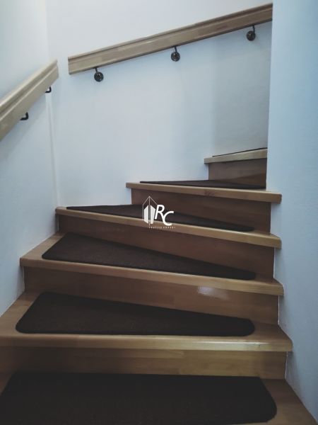 Interior with wooden stairs and railing in a family house.