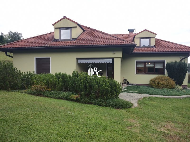 A family house in Trebostovo with a garden, a sloped roof, and a green facade.